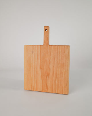 Wooden cutting board with a handle on a gray background