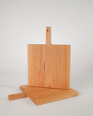 Wooden cutting board with handle on a light gray background
