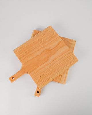 Two wooden cutting boards with handles on a light gray background