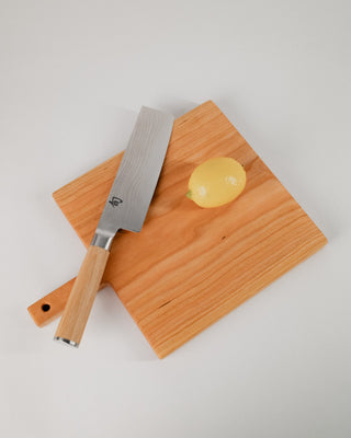 Knife and cutting board on a light gray background