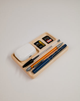 Monolith Desk Tray in maple styled with AirPods, pens, and small accessories in compartments