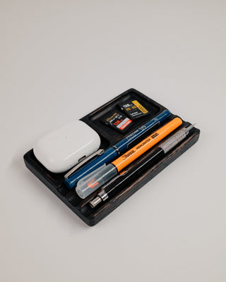 Monolith Desk Tray in black oak styled with AirPods, pens, and everyday carry items