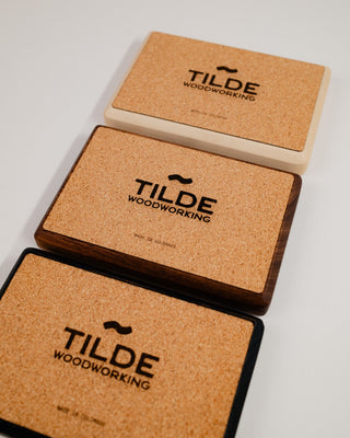 Monolith Desk Tray packaging — three Tilde Woodworking branded cork bases stacked at an angle