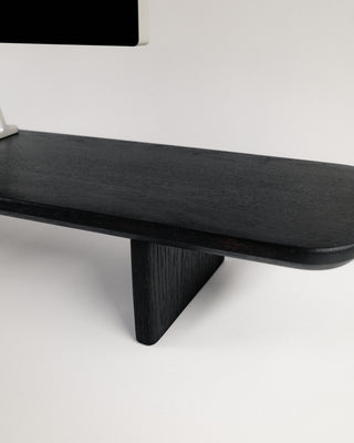 Monolith Desk Shelf black oak surface detail showing monitor stand cutout and rounded edge profile