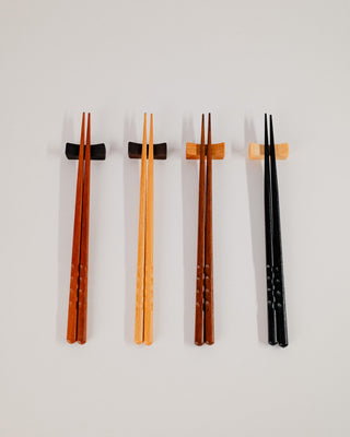 Four chopstick rests in a row on a light gray background

