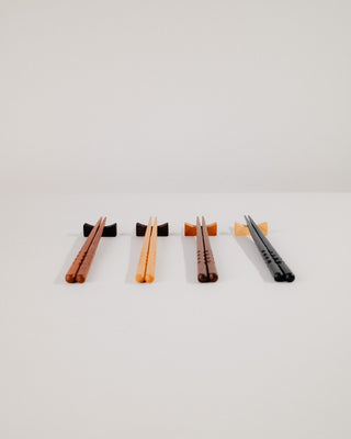 Four chopstick rest sets in cherry, maple, walnut, and Indian laurel lined up diagonally
