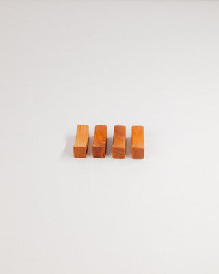 Four cherry chopstick rests in a row on a light gray background