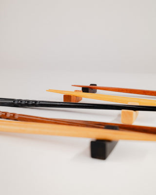 Close-up of chopsticks resting on a solid cherry chopstick rest